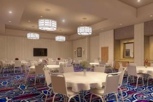 SpringHill Suites by Marriott Fayetteville Fort Liberty في فايتفيل: قاعة احتفالات بها طاولات وكراسي واضاءات
