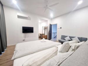 a white bedroom with a large bed and a couch at H+M Residence [5min]to Setia City Convention in Shah Alam