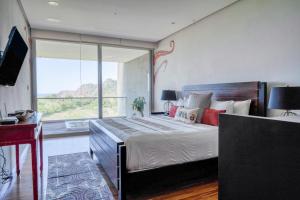 a bedroom with a large bed with a large window at Altos de Montserrat 2 1 in Herradura +31 photos