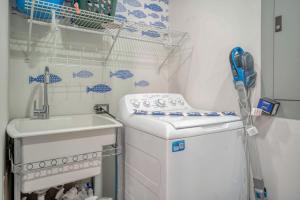 a small kitchen with a sink and a washing machine at Altos de Montserrat 2 1 in Herradura