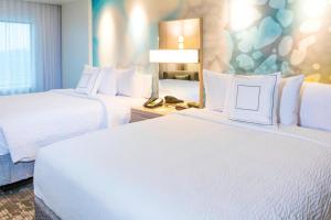 a hotel room with two beds and a phone at Courtyard by Marriott St. Augustine Beach in Saint Augustine Beach