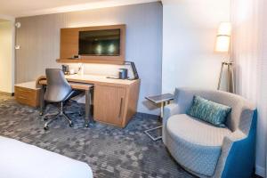 a hotel room with a desk and a chair and a bed at Courtyard by Marriott St. Augustine Beach in Saint Augustine Beach