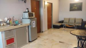 a kitchen and living room with a refrigerator and a microwave at Bercham Vacation House in Ipoh
