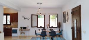 een keuken en eetkamer met een tafel en stoelen bij "IRO HOUSE" Μεζονέτα 600μ από την παραλία in Gerani
