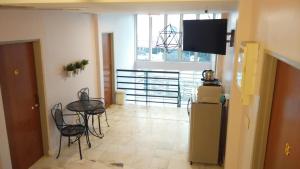 a living room with a table and chairs and a television at Bercham Vacation House in Ipoh