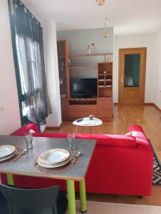 Una sala de estar con un sofá rojo y una mesa. en Conchy House, en Zamora 7 fotos más