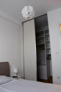 um quarto com uma cama branca e um closet em Barbara em Zagreb