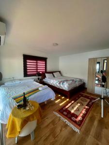 um quarto com 2 camas, uma mesa e uma janela em פינת ביאן נוף לאגם em Majdal Shams