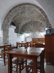 a dining room with wooden tables and a stone wall at Borgo Sciugolo in Baselice