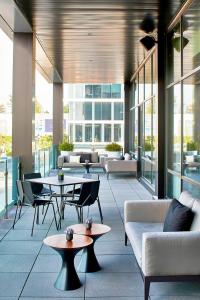 a lobby with tables and couches in a building at AC Hotel by Marriott Cleveland Beachwood in Beachwood