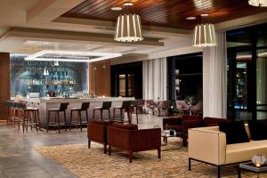 a hotel lobby with a bar with chairs and tables at AC Hotel by Marriott Cleveland Beachwood in Beachwood