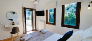 a bedroom with a bed and two windows at "IRO HOUSE" 600m from the beach in Gerani