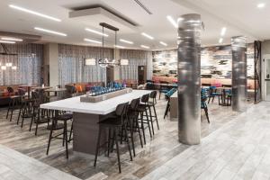 a restaurant with a bar with chairs and tables at Courtyard by Marriott Fort Worth Historic Stockyards in Fort Worth