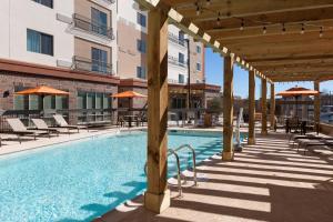 a swimming pool with chairs and umbrellas next to a building at Courtyard by Marriott Fort Worth Historic Stockyards in Fort Worth