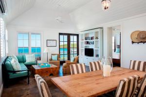 a living room with a wooden table and chairs at French Leave Resort, Autograph Collection in Governorʼs Harbour