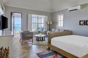 a bedroom with a bed and a living room at French Leave Resort, Autograph Collection in Governorʼs Harbour