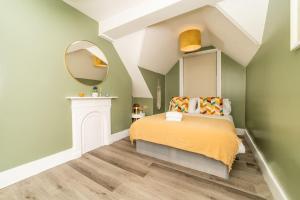 1 dormitorio con 1 cama con espejo en la pared en [Olympia-Museums-Kensington]London Apartment, en Londres