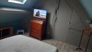 een slaapkamer met een bed en een televisie op een dressoir bij le havre de paix in Devay