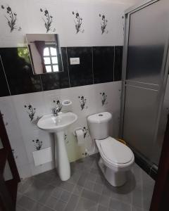 a bathroom with a toilet and a sink at Wikungo Hotel in Puerto Nariño