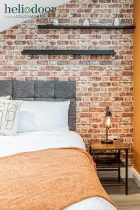 a bedroom with a brick wall and a bed at HAML Heliodoor Apartments Milton Keynes, Free Parking, Free WiFi & Movies, 7-min drive to City Centre in Wolverton