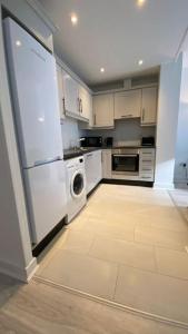a kitchen with a white refrigerator and a dishwasher at Stunning Modern 2bed Apt Near Dublin City& Airport in Dublin