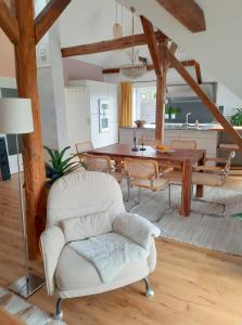 ein Wohnzimmer mit einem weißen Stuhl und einem Tisch in der Unterkunft Luxuriöses Loft mit schönem Blick in Tremsbüttel