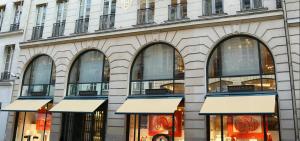 Chic Apartment on the famous shopping Rue du Faubourg Saint-Honoré street في باريس: متجر أمام مبنى به نوافذ