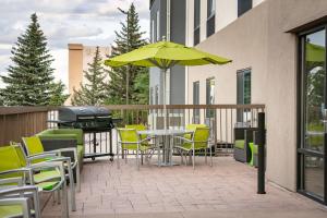 eine Terrasse mit einem Tisch, Stühlen und einem Grill in der Unterkunft SpringHill Suites by Marriott Cheyenne in Cheyenne