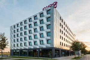 an office building with a sign on top of it at Moxy Berlin Airport in Schönefeld