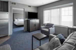 a living room with a couch and a television and a bed at Residence Inn by Marriott Orangeburg in Orangeburg