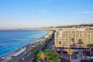 uitzicht op een hotel en de oceaan bij Le Meridien Nice in Nice