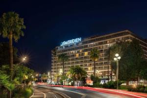 a building with a sign on top of it at night at Le Meridien Nice in Nice