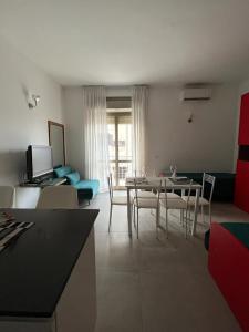 een woonkamer met een tafel en stoelen en een bank bij Un balcone sul mare in Gallipoli