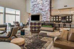 a lobby with a bar with chairs and a fireplace at Residence Inn by Marriott Dallas DFW Airport West/Bedford in Bedford