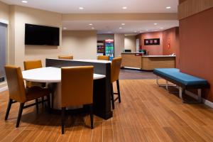 uma sala de espera com uma mesa e cadeiras em TownePlace Suites by Marriott St. Louis Chesterfield em Chesterfield