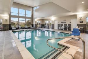 a swimming pool with chairs and tables in a building at Residence Inn by Marriott Dallas DFW Airport West/Bedford in Bedford