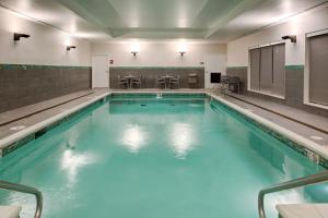 TownePlace Suites by Marriott St. Louis Chesterfield في تشيسترفيلد: مسبح بمياه زرقاء في مبنى