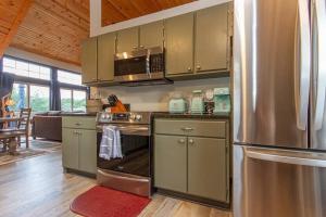 a kitchen with a stainless steel refrigerator at Gorgeous cabin 3bdrm/3bth, hot tub, fireplace, kid/pet friendly in Galena