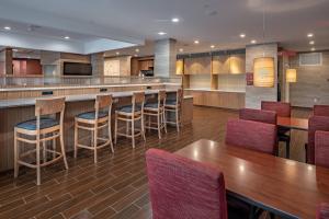 TownePlace Suites by Marriott Dallas Mesquite في ميسكوايت: مطعم فيه بار فيه كراسي وطاولات