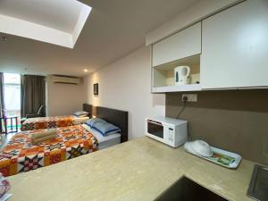 a hotel room with two beds and a microwave at Cyber Studio Apartment in Kota Bharu