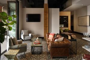 a living room with couches and chairs and a tv at Epicurean Hotel, Autograph Collection in Tampa