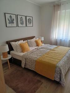 1 dormitorio con 1 cama grande con almohadas en Centrum Apartman Kőszeg, en Kőszeg