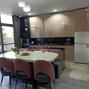 eine Küche mit Tisch und Stühlen und einem Kühlschrank in der Unterkunft 2 Bedroom+Garden, Lakes near AUC in New cairo