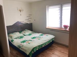 um quarto com uma cama com colcha floral em Dom pod barankiem em Mielno