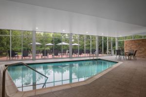 uma piscina num edifício com mesas e cadeiras em Fairfield by Marriott Inn & Suites Washington Casino Area em Washington