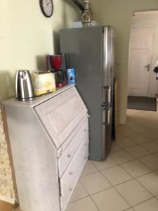 kuchnia z lodówką i szafkami ze stali nierdzewnej w obiekcie Dom pod barankiem w mieście Mielno