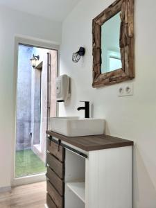 a bathroom with a sink and a mirror at Le Grand Evali - WIFI - Centre in Albi