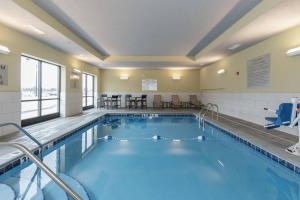 a pool in a hotel room with tables and chairs at Courtyard by Marriott South Bend Downtown in South Bend