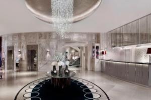 a lobby with a chandelier and a table with flowers at The Park Tower Knightsbridge, a Luxury Collection Hotel, London in London