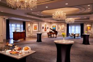 a large room with a piano and tables and chandeliers at The Henry, Autograph Collection in Dearborn
